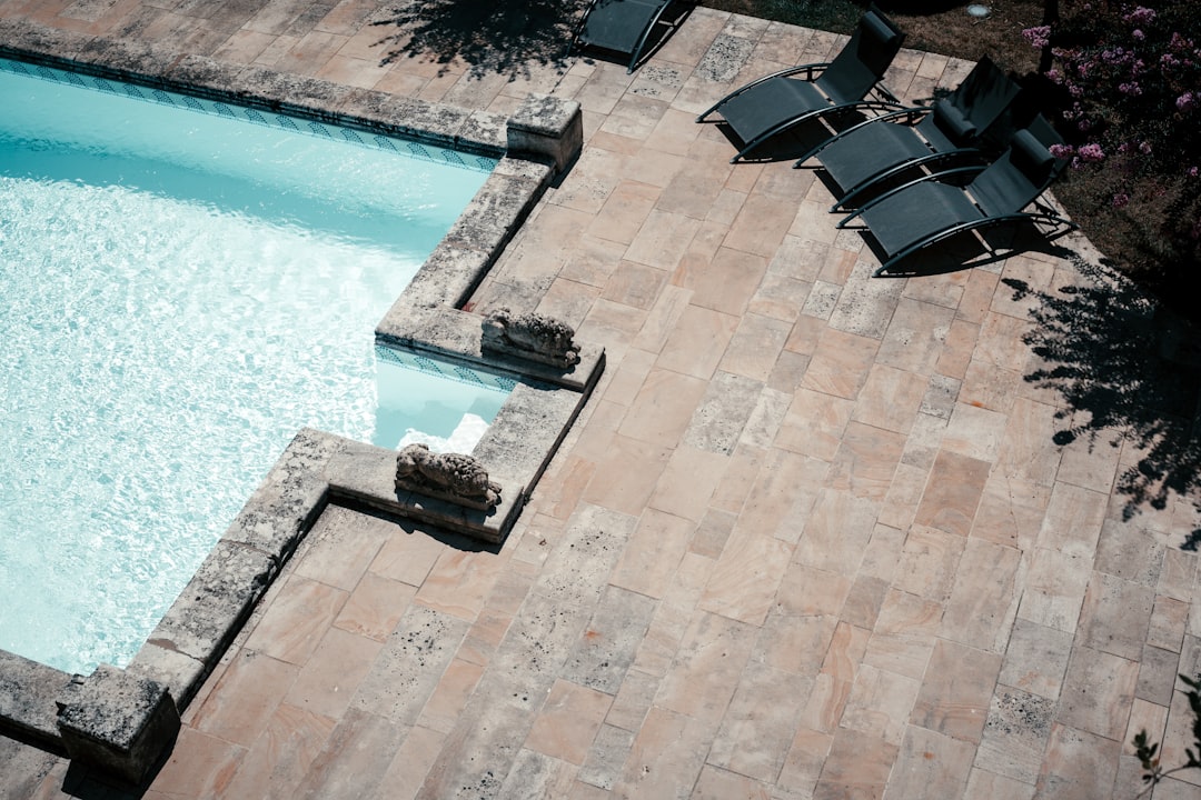 Estate hardscape pool deck with travertine pavers and structural outdoor design