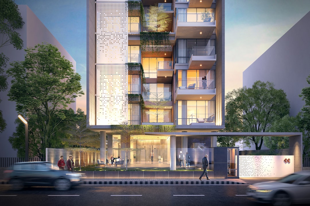 Naples estate after dark with warm amber palm uplighting and water feature illumination