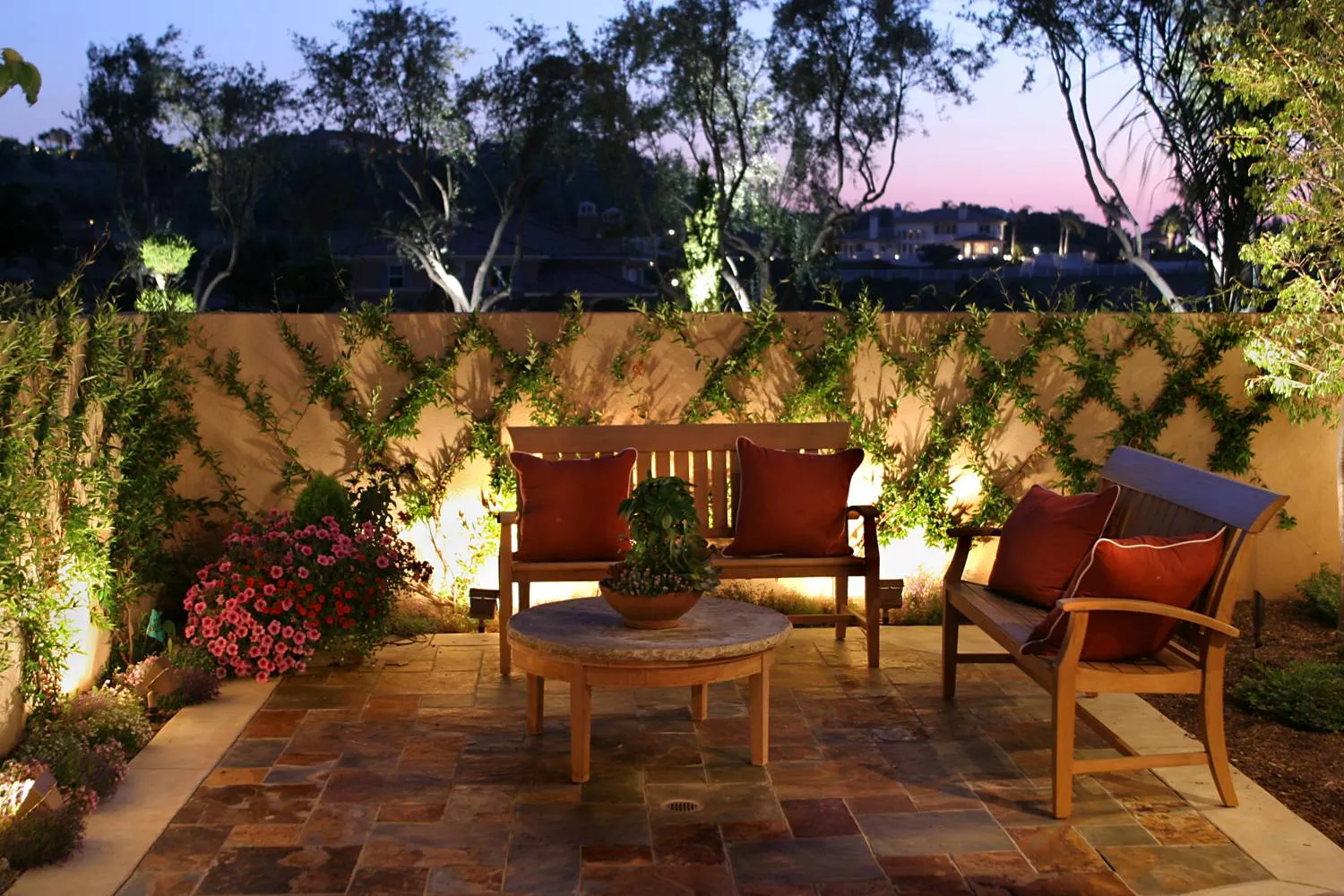 Twilight estate garden terrace with uplighting and tropical planting