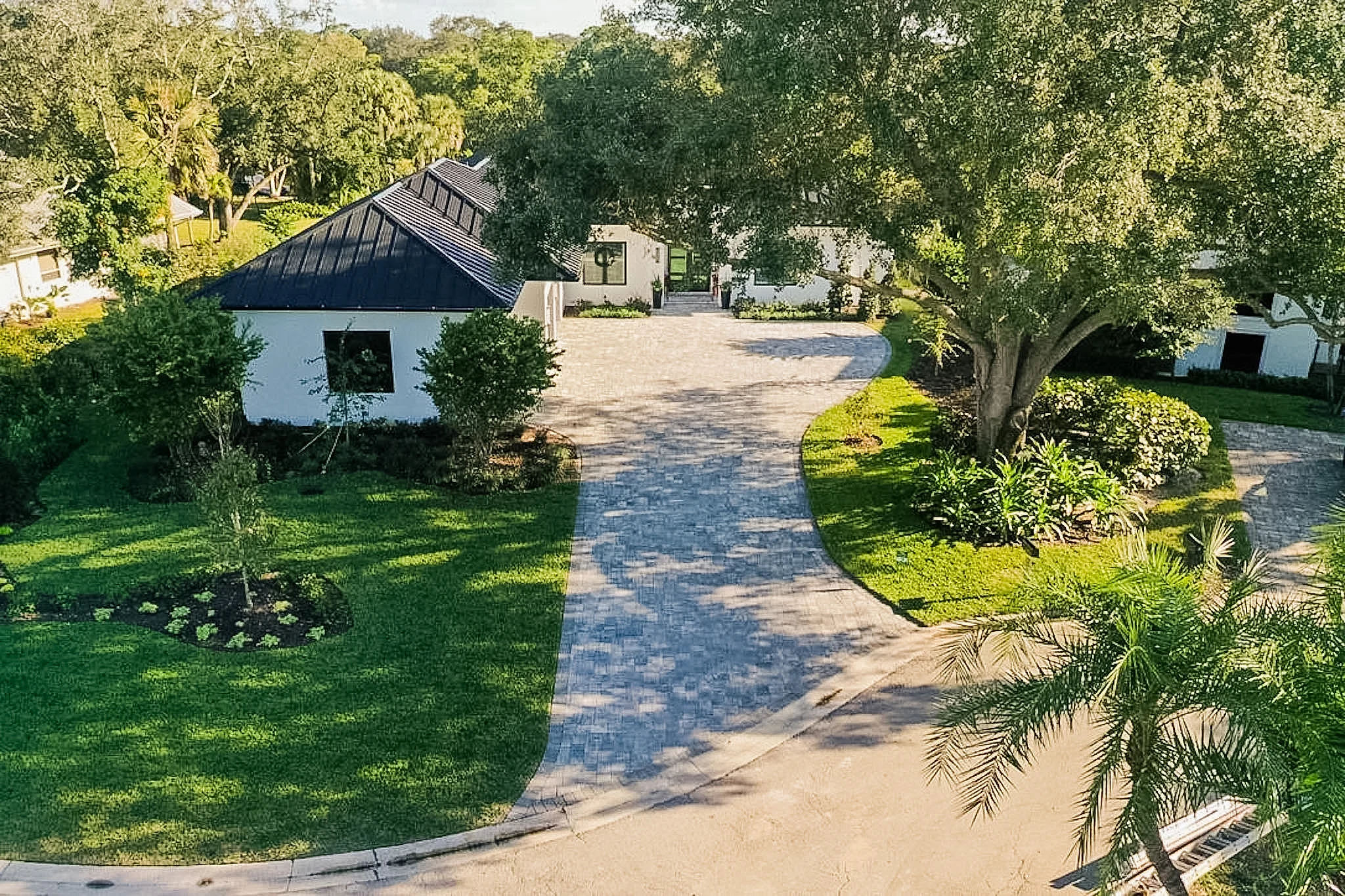Aerial view of curved paver driveway and estate grounds — Naples, FL