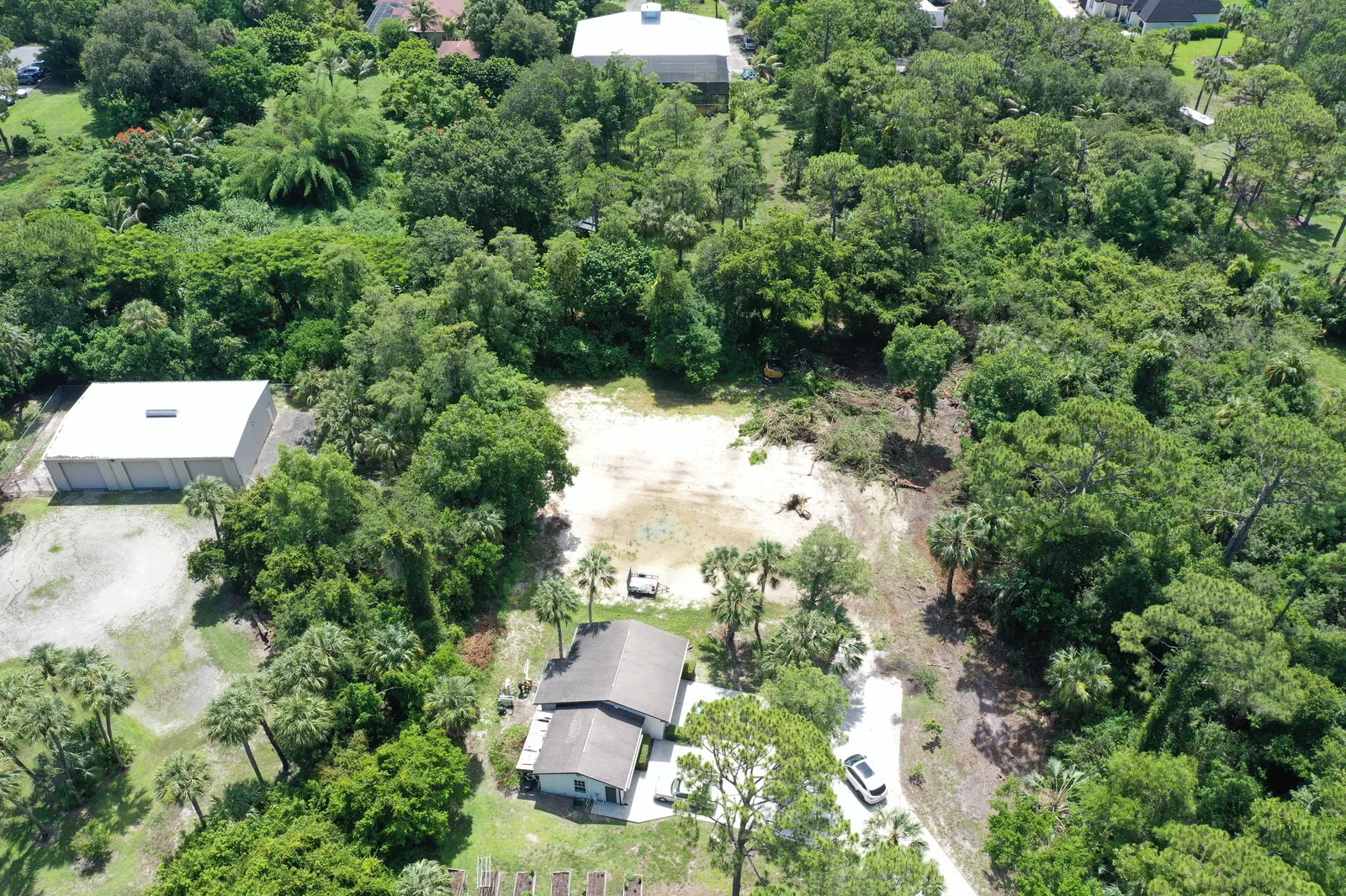 East Naples lot clearing — sand pad after vegetation removal, Collier County