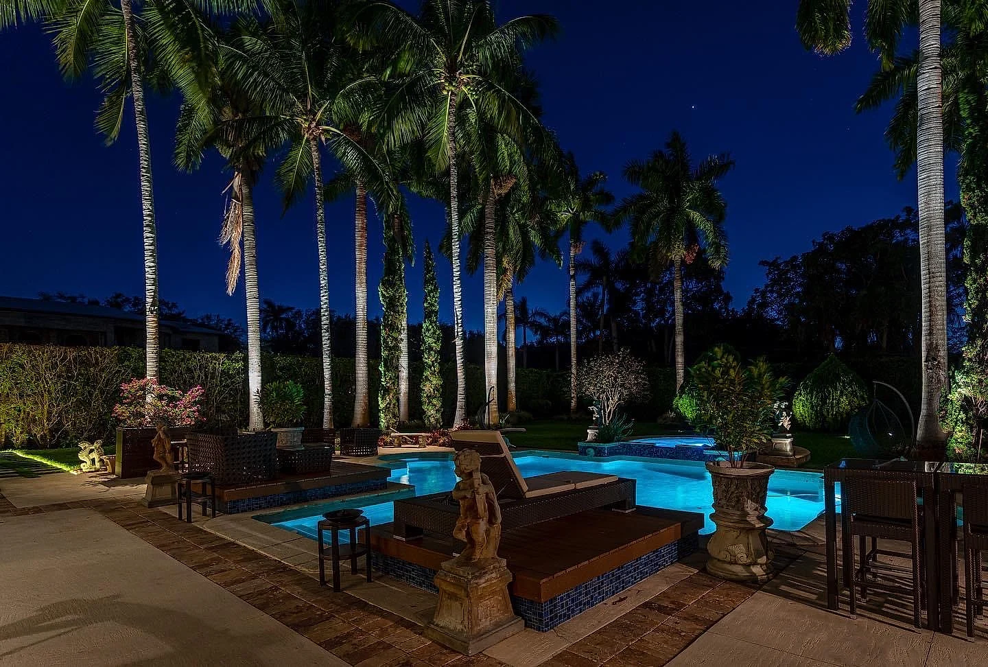 Estate pool and landscape lighting at night — palm tree uplighting — Naples, FL
