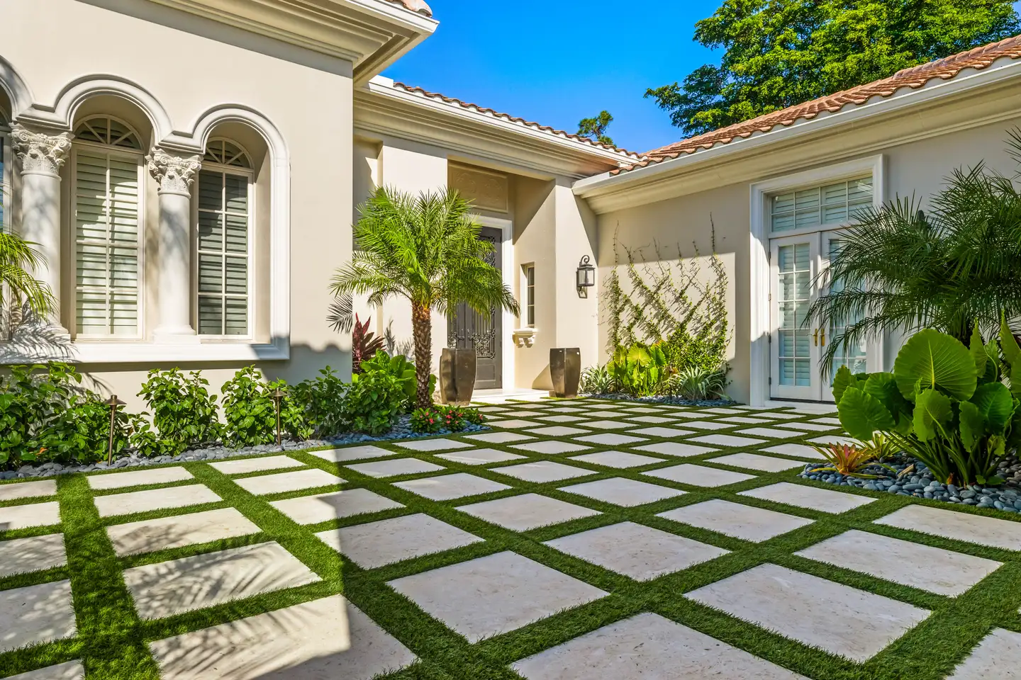 Mediterra estate paver courtyard — large-format white pavers with synthetic turf grid pattern