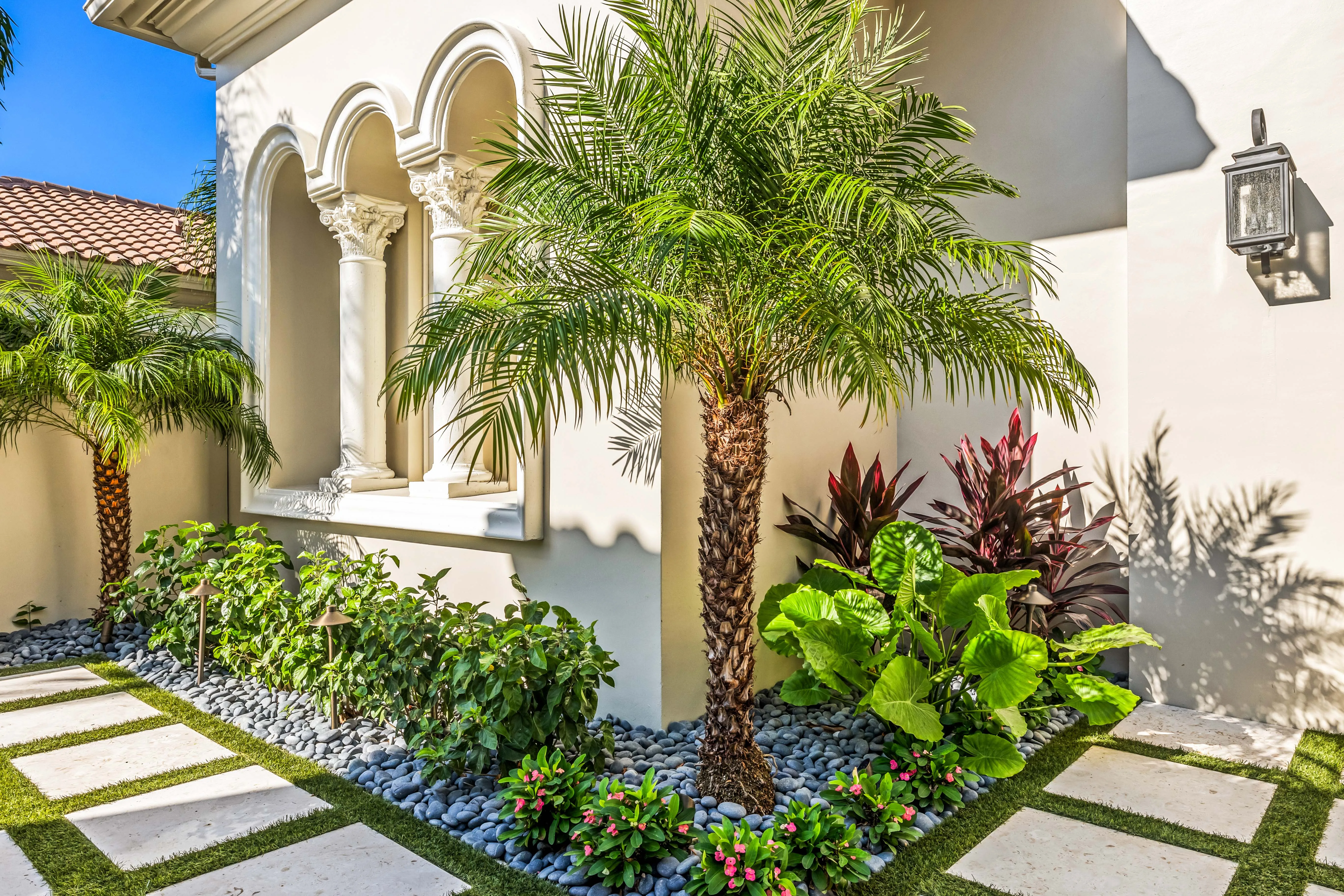 Palms, planting, and lighting as one layer on a Naples estate